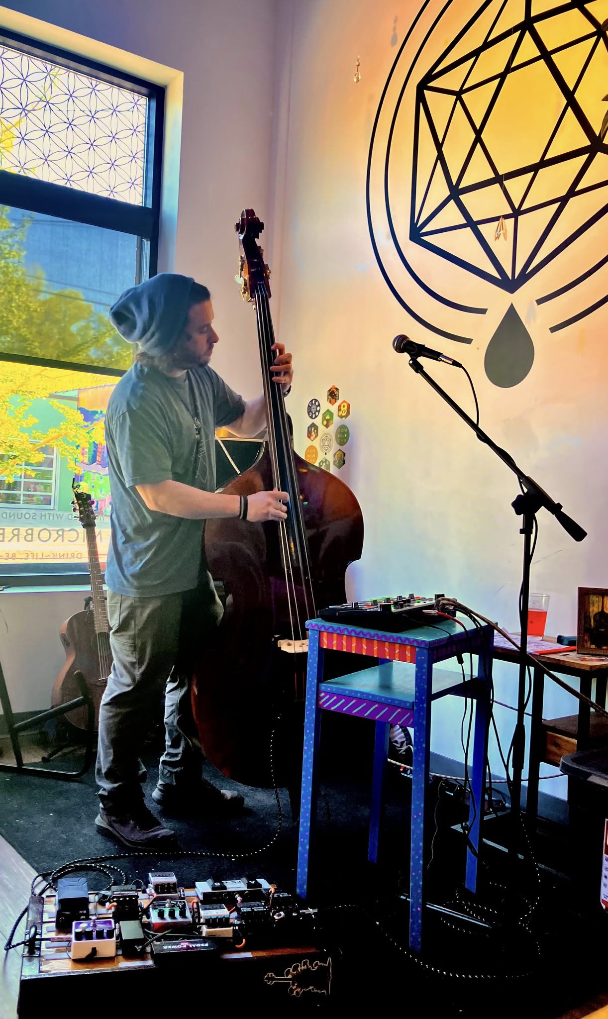 Zach playing upright bass beside his live looper and effects pedals