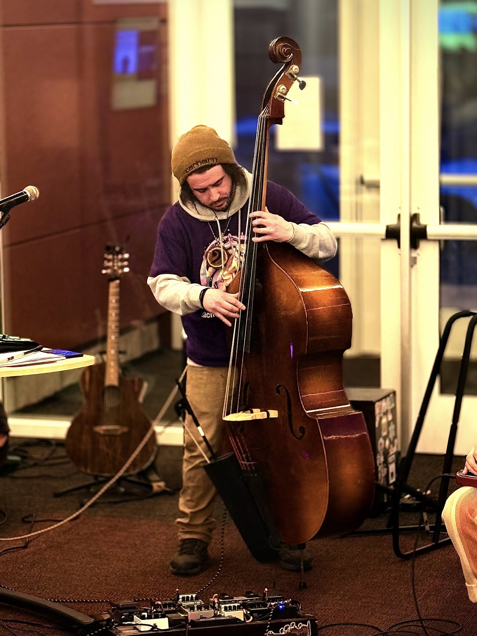 Zach Gregory playing upright bass with his pedalboard at his feet